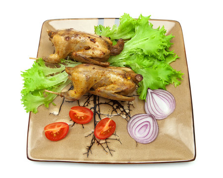 woodcocks fried with vegetables on a plate. white background.