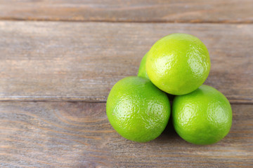 Fresh juicy limes on wooden background
