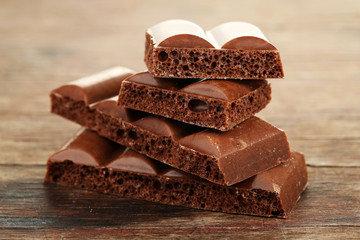 Tasty porous chocolate on wooden table