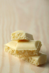Tasty white porous chocolate on wooden table, close up