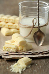 Tasty white porous chocolate and glass of milk,