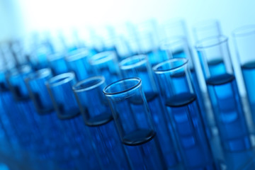 Blue water in a transparent test-tube on light background