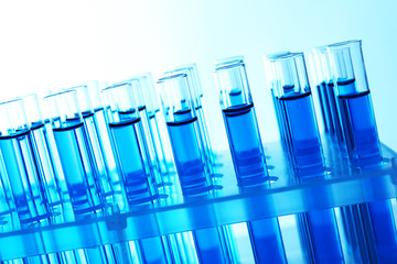 Blue water in a transparent test-tube on light background