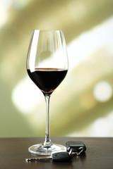 Glass of alcoholic drink and car key,