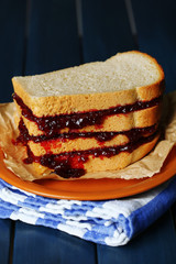 Tasty sandwich with jam on wooden table