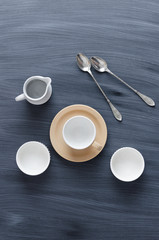 Empty coffee cups, milk jar and spoons