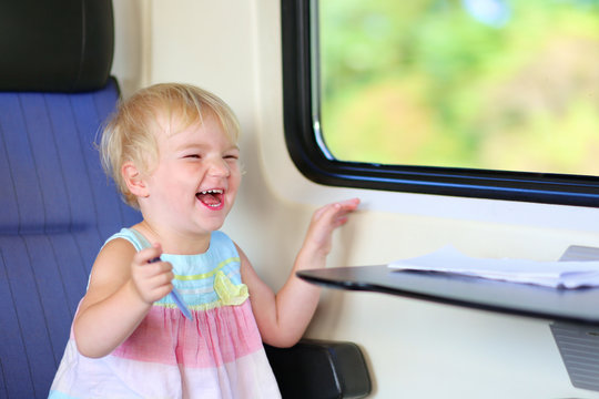 Happy little girl enjoying trip by train