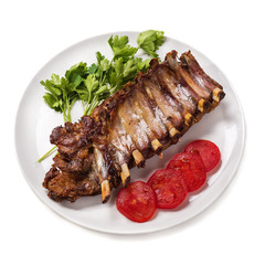 Baked pork ribs with vegetables isolated on white background