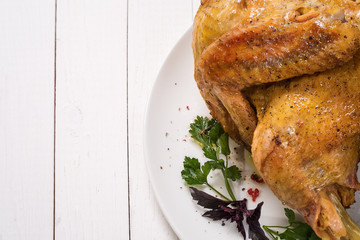 Baked chicken with spices on a light wooden table and place for