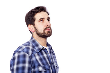 Fototapeta premium Pensive casual man looking up, isolated over white background