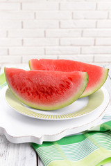 Juicy watermelon on table on brick wall background