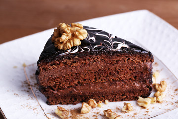 Delicious chocolate cake on plate on table close-up