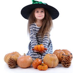 Little girl Witch in hat with pumpkins isolated on white