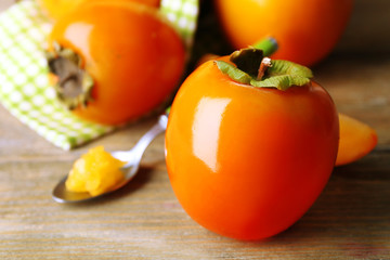 Ripe persimmons on wooden background
