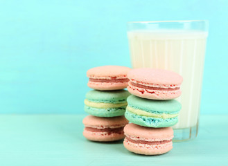 Assortment of gentle colorful macaroons and glass with milk