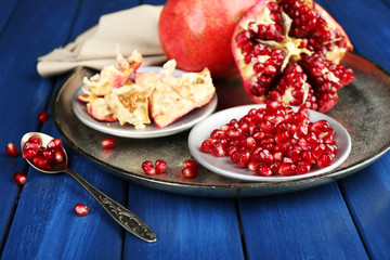 Obraz na płótnie Canvas Juicy ripe pomegranates on wooden table