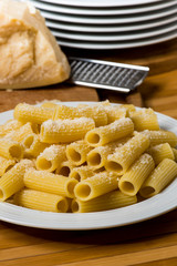 italian food called pasta with parmesan cheese on background