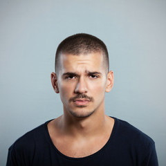 Fototapeta premium Portrait of confused or sad young man. Studio Shot