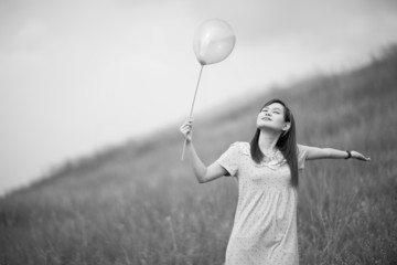 girl with balloons in a field