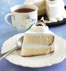 Piece of cake on plate and cup of tea
