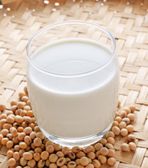 Soy milk and beans on wood background