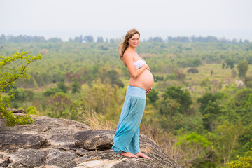 Naklejka premium Beautiful pregnant woman relaxing outside in the park