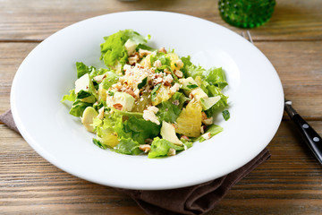 Fresh salad with avocado, orange and crushed nuts on a bowl