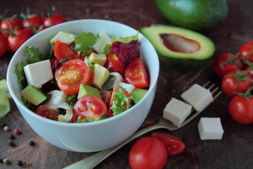 Bowl with vegetable salad with tomatoes lettuce and feta cheese