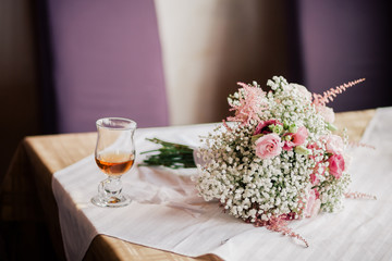 wedding bouquet  and  a cup of tea on the table