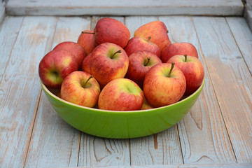 Verse appels in groene fruitschaal op oud hout