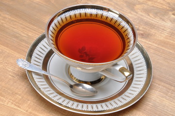 Tea in old cup on wooden board