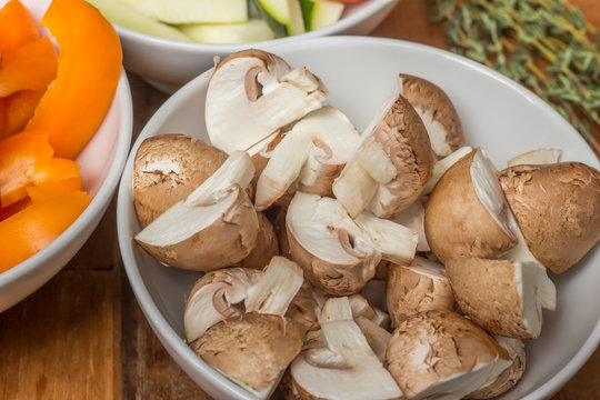 Cut chestnut mushrooms in a white bowl