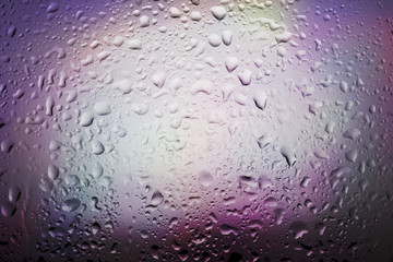 Abstract background water drops on glass withcolorful light.