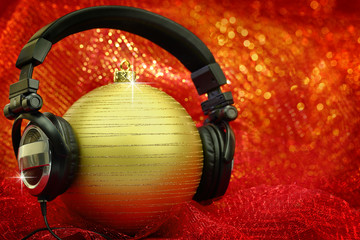 Christmas ball with headphones in glittering background