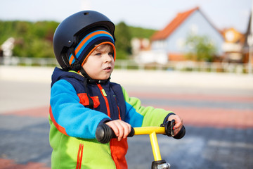 Fototapeta na wymiar Little toddler boy learning to ride on his first bike