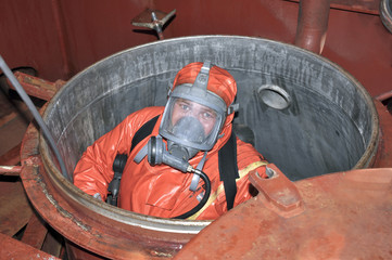 man in chemical suit entering inside cargo tank - 74715121