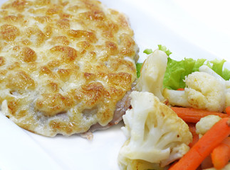Close up of baked cutlet with vegetables