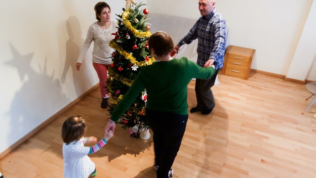 Happy family with children decorating Christmas tree at home