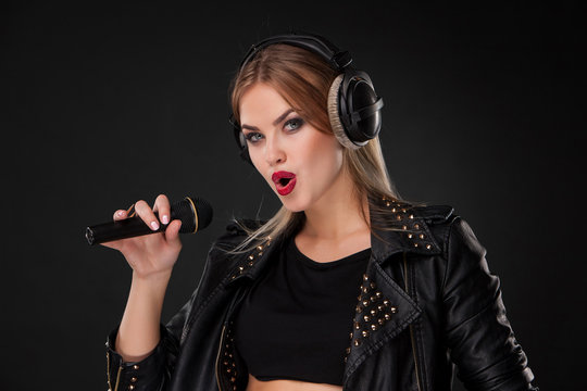 Portrait of a beautiful woman singing into microphone with