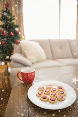 Composite image of cookies and mug on coffee table at christmas
