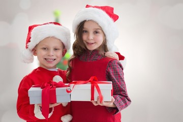 Fototapeta na wymiar Composite image of cute siblings with gifts
