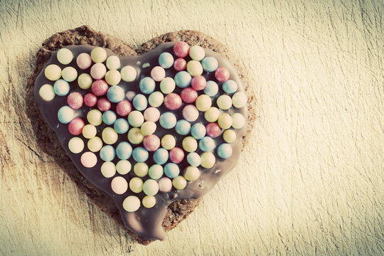Handmade gingerbread heart decorated with colorful sugar pearls