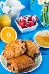 Table view on croissant with fresh strowberries and orange juice