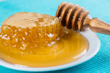 cloese view on fresh honey and wooden dipper