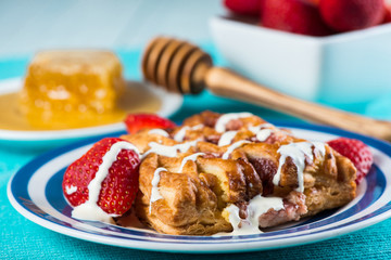Fresh croissant with honey and strawberry