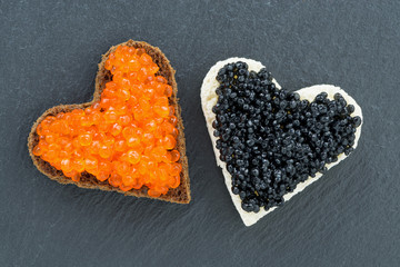 toast with red and black caviar in the form of heart on dark