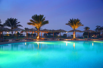 Fototapeta na wymiar tropical resort pool at sunset