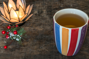 A cup of hot tea with lemon on rustic wooden table, close-up