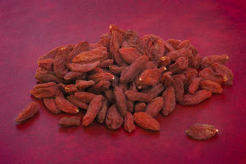 dry goji berries (Lycium barbarum) on red background