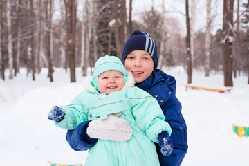 Fototapeta na wymiar Happy family teenager and baby boy kid in winter park
